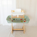 Sage-green high chair food catcher tray on a linen backdrop